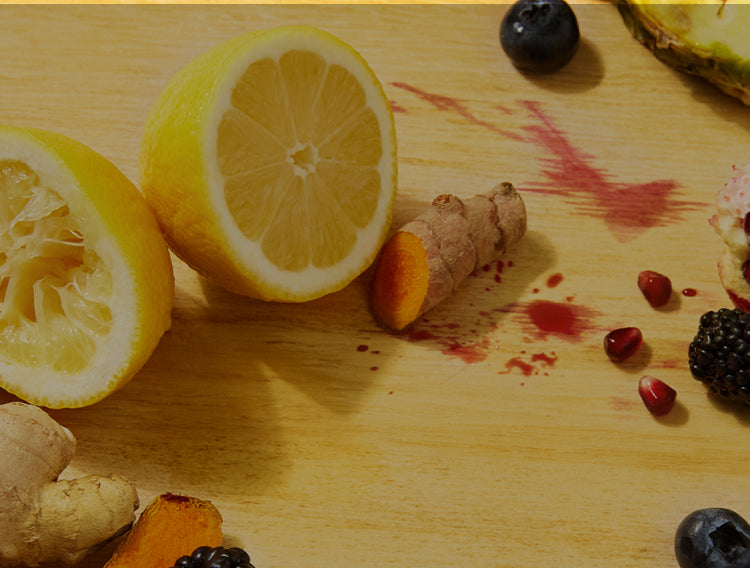 fresh lemon, blueberries, pomegranate, ginger, turmeric ingredients on a chopping board