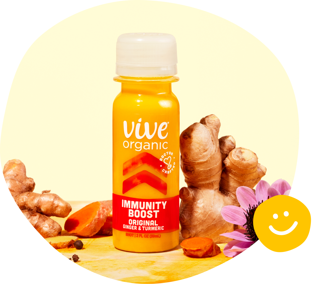 immunity boost shot bottle with ginger and turmeric fresh ingredients around the product