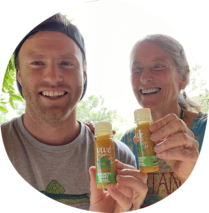 Wyatt Taubman with Dr. Erica Elliott holding immunity boost cayenne shots in their hands smiling.